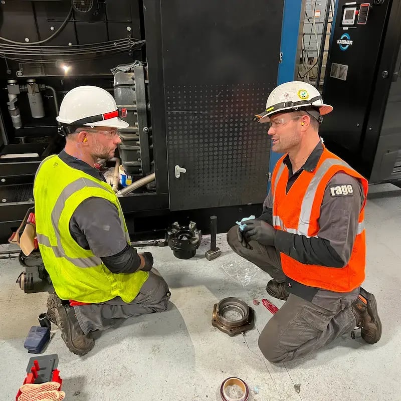 Two Rage employees working on an air unit
